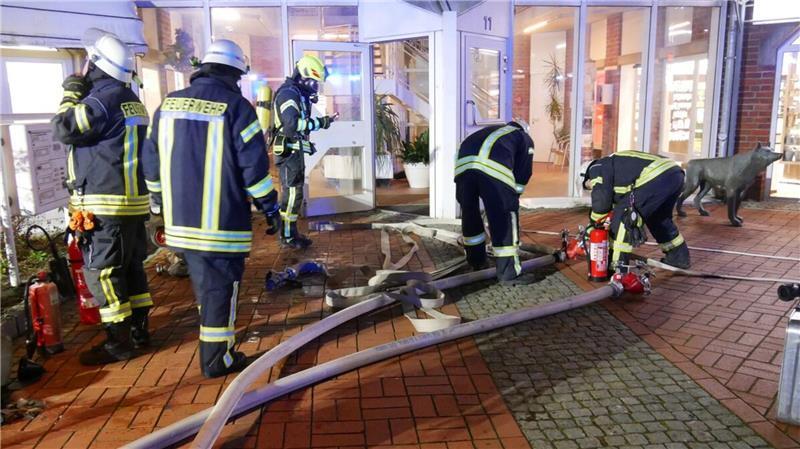 Während sich die Atemschutzgeräteträger ausrüsteten, verlegten Einsatzkräfte von wasserführenden Fahrzeugen aus Schlauchleitungen in das Gebäude.