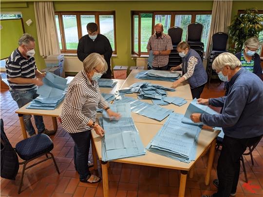 Wahlhelfer zählen im Dorfgemeinschaftshaus Steinkirchen Stimmzettel aus, hier sind sie mit Wahlscheinen für den Kreistag beschäftigt. Foto: Battmer