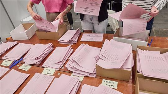 Wahlhelferinnen in den Messehallen zählen nach der Bezirksversammlungswahl die Stimmen aus.