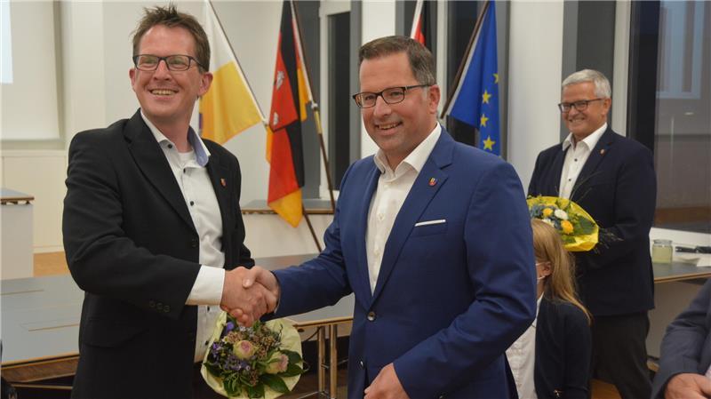 Wahlsieger Kai Seefried (rechts) und sein Herausforderer Björn Protze nach der Wahl 2021. Im Hintergrund: der langjährige Amtsinhaber Michael Roesberg.