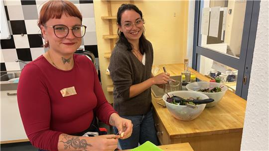 Wala (links) und Cheyanne bereiten in der Küche der Volkshochschule Buxtehude Salat für alle zu.