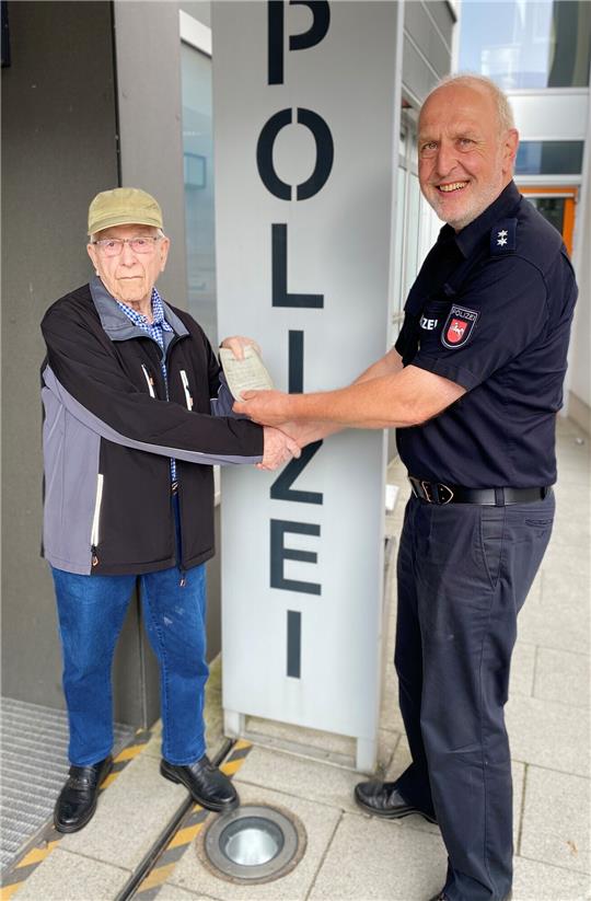 Walter Dahl aus Buchholz übergibt seinen Führerschein an Dirk Poppinga von der Polizeiinspektion Harburg. Foto: Polizei