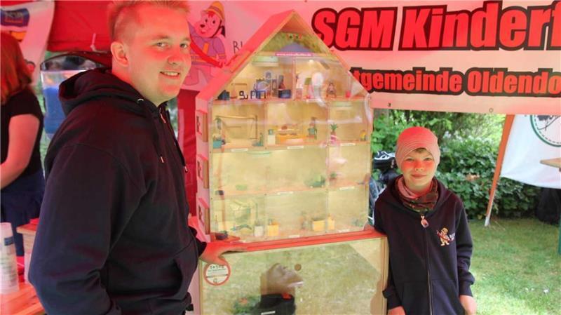 Himmelpforten: Alle samt feierten die Vereine ein fröhliches Fest Was wie ein Puppenhaus wirkt, ist das „Rauchhaus“, das die Feuerwehr der Samtgemeinde mitbrachte. Max Brinkmann erklärt es dem neunjährige Dennis von der Kinderfeuerwehr „Blaulicht-Bande“.
