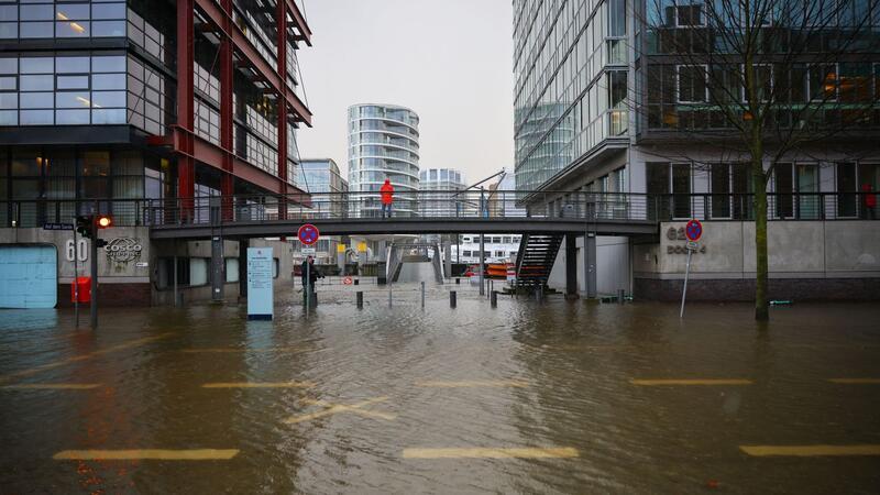 Wasser steht auf der überschwemmten Straße „Am Santorkai“ in der Hafencity.