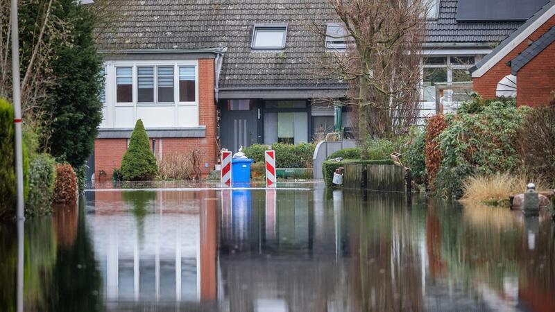 Wasser steht in einer evakuierten Wohnstraße nahe der Wörpe in Lilienthal.