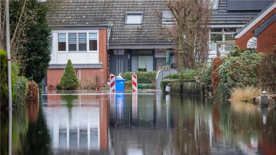 Wasser steht in einer evakuierten Wohnstraße nahe der Wörpe in Lilienthal.