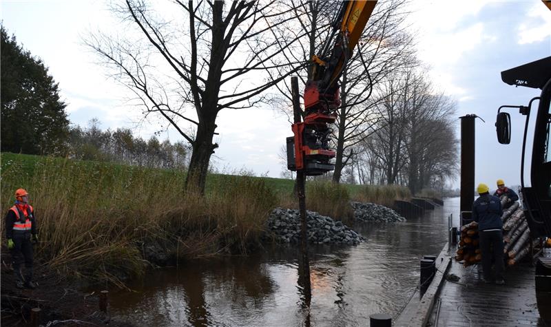 Wasserbau-Azubi Jannes Geisler nimmt am Oste-Ufer Buschmatten entgegen, auf denen später eine Buhne aufgeschüttet wird. Fotos von Borstel