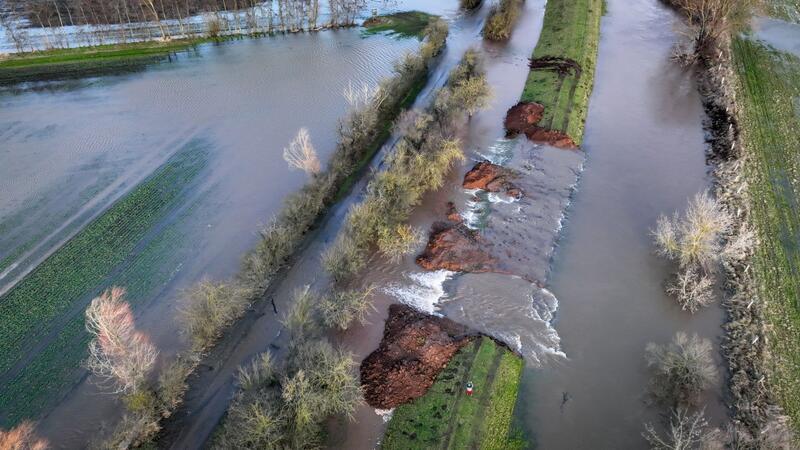 Keine Entwarnung in Hochwasser-Gebieten Wassermassen fließen durch die Deichöffnung am Fluss Helme im nordthüringischen Kyffhäuserkreis auf die umliegenden Flächen.