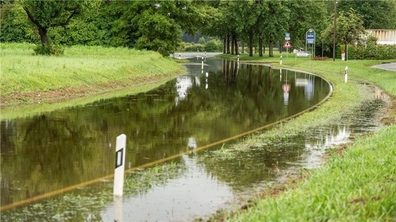 Bilder des Tages „Wasserstraße“: Die Landstraße 220 bei Böhringen im Landkreis Konstanz ist nach Starkregen überschwemmt und sieht aus wie ein Fließgewässer.