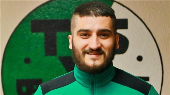 Yagiz Sinan lächelt in grüner Sportjacke.