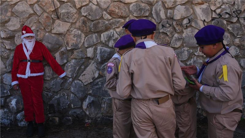 Weihnachten in Nazareth - Jugendlicher im Weihnachtsmannkostüm wartet mit Pfadfindern auf Weihnachtsparade
