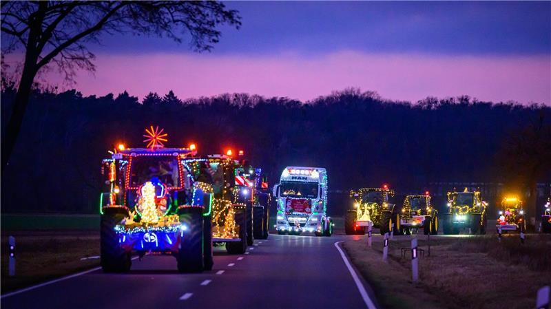 Weihnachtlich beleuchtete und geschmückte Traktoren und Lkw sind bei der Lichterfahrt der Oderlandbauern in Brandenburg unterwegs. 
