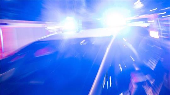 Ein Polizeiauto steht vor einem Hochhaus in Berlin-Schöneberg, in dem es gebrannt hat. 