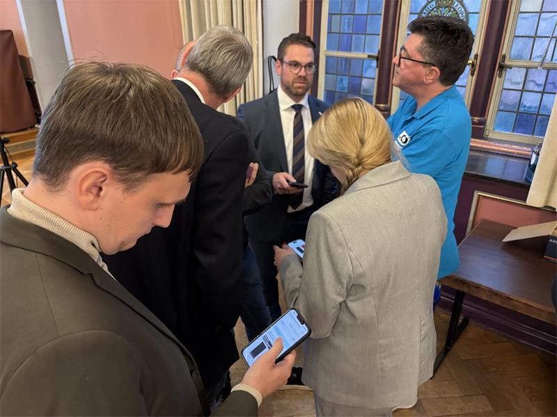 Weil es im Rathaus technische Probleme gab, mussten sich Arne Kramer (Mitte) und seine Unterstützer sowie alle anderen Besucher anfangs per Smartphone über den aktuellen Stand informieren.