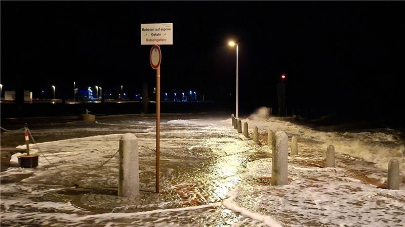 Wellen überspülen die Promenade in Wilhelmshaven.