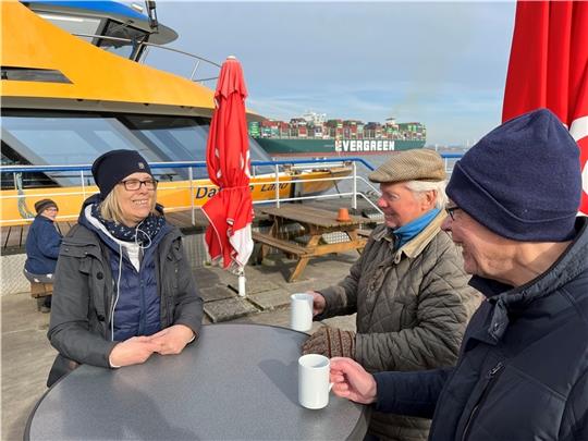 Wellenreiter-Wirtin Sylke Oehr hofft auf eine gute Saison auf dem Ponton. Bernd Schnell und Johann Arp zählen zu ihren Stammgästen. Guter Kaffee und Schiffe gucken, das verbinde sie mit dem Lühe-Anleger. Fotos: Vasel