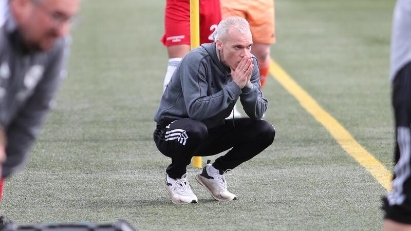 Wenige Augenblicke vor dem Elfmeter: Der Deinster Trainer kniet vor seiner Bank und scheint zu beten.