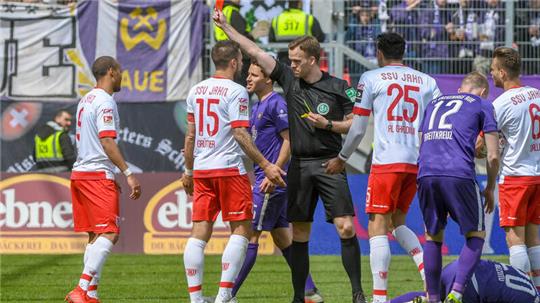 Jann George von Regensburg (l) bekommt von Schiedsrichter Pascal Müller die Rote Karte.