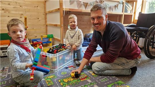 Wenn Leon Wittler mit seinen Söhnen Bennet (links) und Theo die beliebte Lego-Eisenbahn aufbaut, kann sein Rollstuhl, auf den er sonst angewiesen ist, eine Weile in der Ecke stehen. 