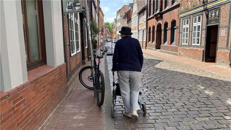 Wenn ein Fahrrad den Gehweg versperrt, muss Erika Schlieper mit ihrem Gehwagen auf das holprige Kopfsteinpflaster ausweichen.