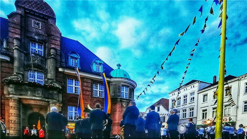 Wenn vor dem Rathaus in Buxtehude der traditionelle Zapfenstreich der Schützengilde von 1583 stattfindet, schmücken Girlanden in Blau und Gelb den Rathausplatz.