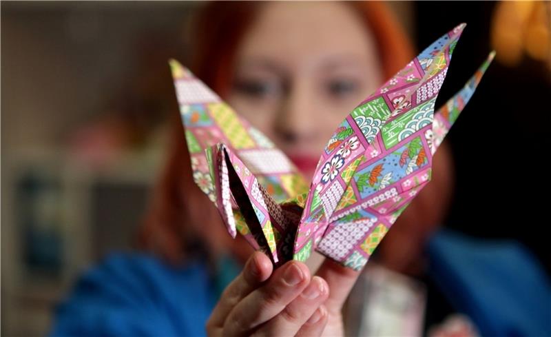 Wer 1000 Origami-Kraniche faltet, bekommt nach einem alten Volksglauben von den Göttern einen Wunsch erfüllt. Else Zager vom Asylkreis Harsefeld wünscht sich Frieden in der ganzen Welt. Foto: Jan Woitas/dpa