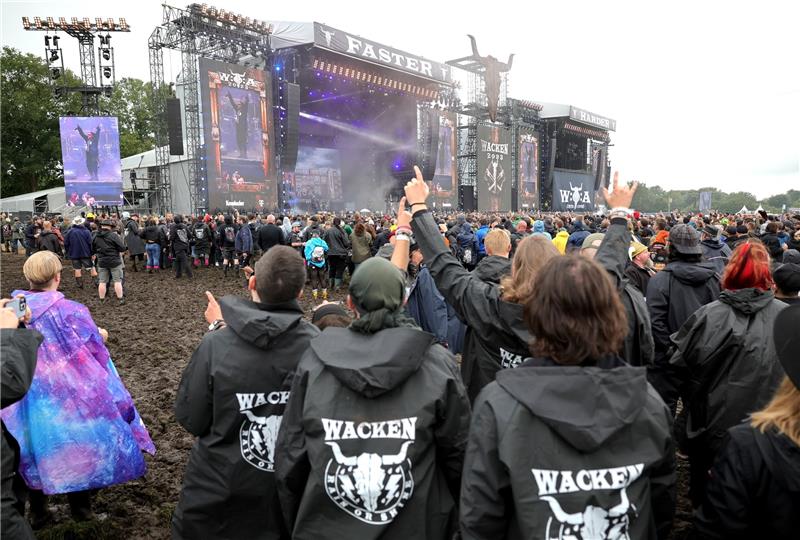„Lasst uns rein”: Bundeswehr hilft in Wacken – Programm gekürzt Wer es geschafft hat reinzukommen, freut sich dabei zu sein - trotz Schlamm und Regen. Foto: dpa