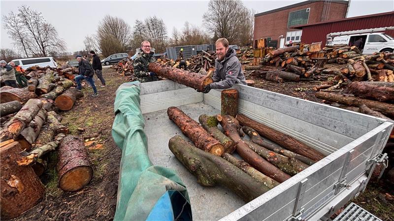 Wer hier Holz ersteigert, muss anschließend schuften: Kay Böhme (links) und Nico Pape laden das ersteigerte Brennholz zum Abtransport auf den Anhänger.