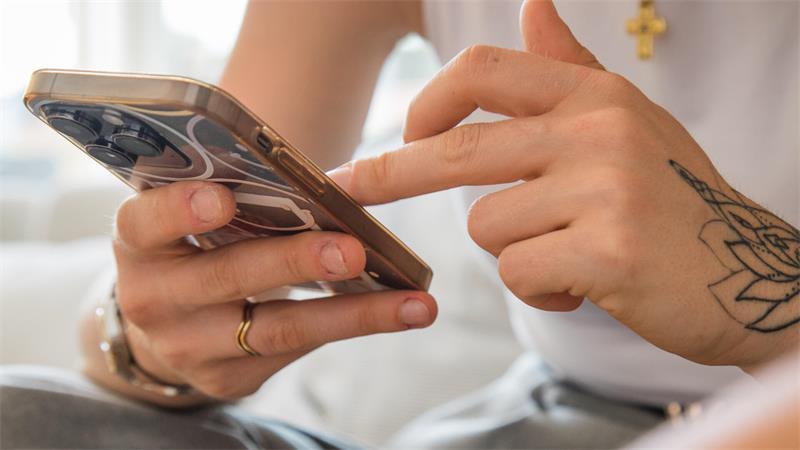 Eine Frau hält ein Smartphone in der Hand.