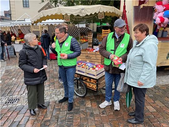 Werben für Altländer Äpfel: Landrat Kai Seefried und Claus Schliecker von der Fachgruppe Obstbau, (2. von rechts) im Gespräch mit den Verbraucherinnen Annegret Winkler und Erika Dieterich (rechts). Foto Vasel
