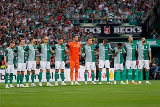Werders Mannschaft bei der Schweigeminute für Werder-Legende Horst-Dieter Höttges, der kürzlich verstorben war. Foto: Axel Heimken/dpa