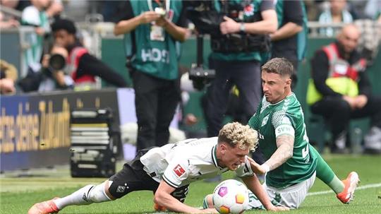 Werders Marco Friedl (r) kämpft gegen Gladbachs Robin Hack um den Ball.