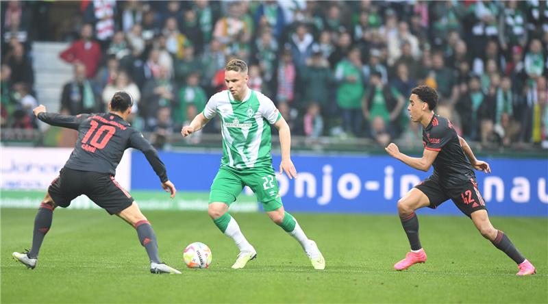 Werders Niklas Schmidt (M) kämpft gegen Bayerns Leroy Sane (l) und Jamal Musiala um den Ball. Werder spielt im Eröffnungsspiel gegen den deutschen Meister Bayern München. Foto: Carmen Jaspersen/dpa