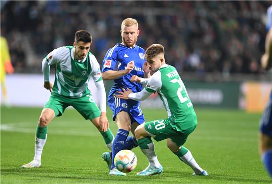 Werders Romano Schmid (re.) und Ilia Gruev (li.) kämpfen gegen Schalkes Florent Mollet um den Ball. Foto: Carmen Jaspersen/dpa