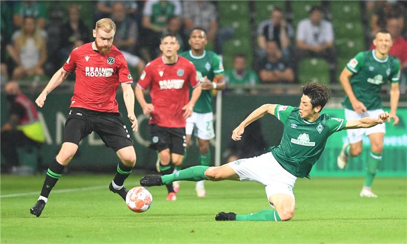 Werders Yuya Osako (r) versucht Hannovers Bo Niklas Hult den Ball abzunehmen. Foto: Carmen Jaspersen/dpa