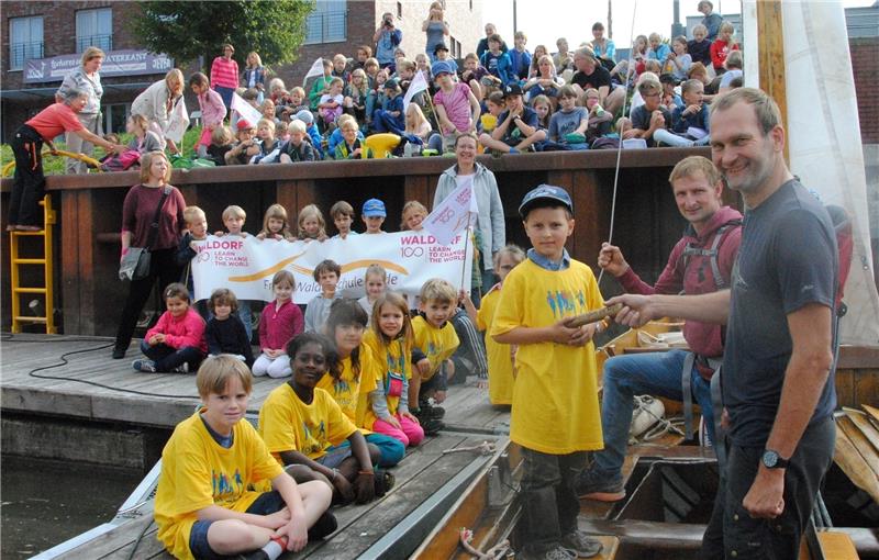 Werklehrer Ulrich Geertz (rechts) hat das Staffelholz mit Kutterführer Kim Holst aus Kolmar abgeholt. Im Stader Hafen wird es stellvertretend für die Schulgemeinschaften in Stade und Apensen an Ole übergeben. Foto Stief