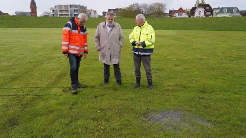 Werner Bentlage (Stadt Cuxhaven, v.l.), Olaf Raffel (Nordseeheilbad Cuxhaven GmbH) und Schultheiß Jürgen Schubel (Cuxhavener Deichverband) inspizieren den Deich.