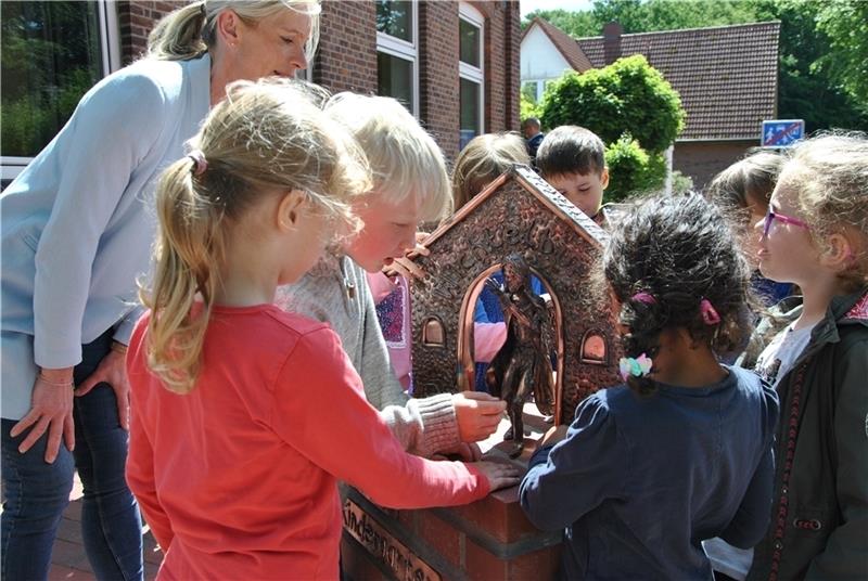 „Wichtelburg“-Kinder bestaunen die Skulptur der Künstlerin Jana Putzehl von der Kupfergalerie Unikate. Foto: Lohmann