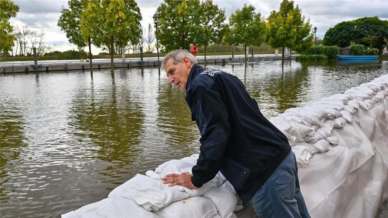 Wie schlimm wird das Hochwasser? Frank Balzer (SPD), der Bürgermeister von Eisenhüttenstadt, blickt über einen Wall aus Sandsäcken im Stadtteil Fürstenberg, wo Straßen überflutet wurden.