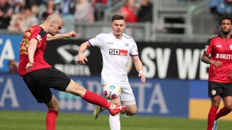 Wiesbadens Aleksandar Vukotic (l) und Osnabrücks Erik Engelhardt (r) kämpfen um den Ball.