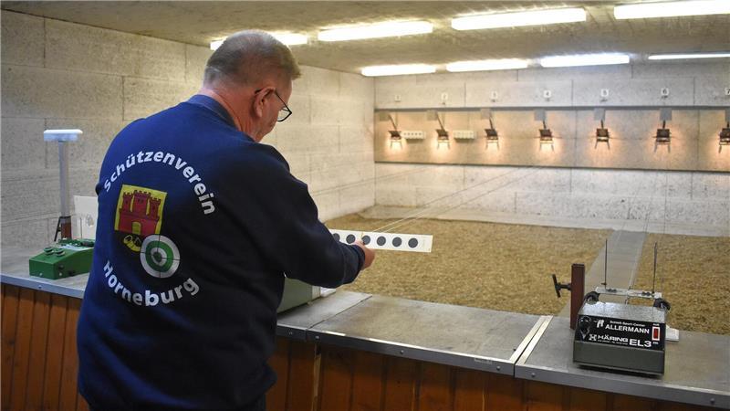 Wilfried Peters spannt Zielscheiben in die alte Zuganlage im Luftgewehrschießstand.