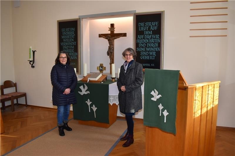 Wilma Matthias vom Kapellenvorstand und Pastorin Manuela Handelsmann am Altar im Gemeindesaal.