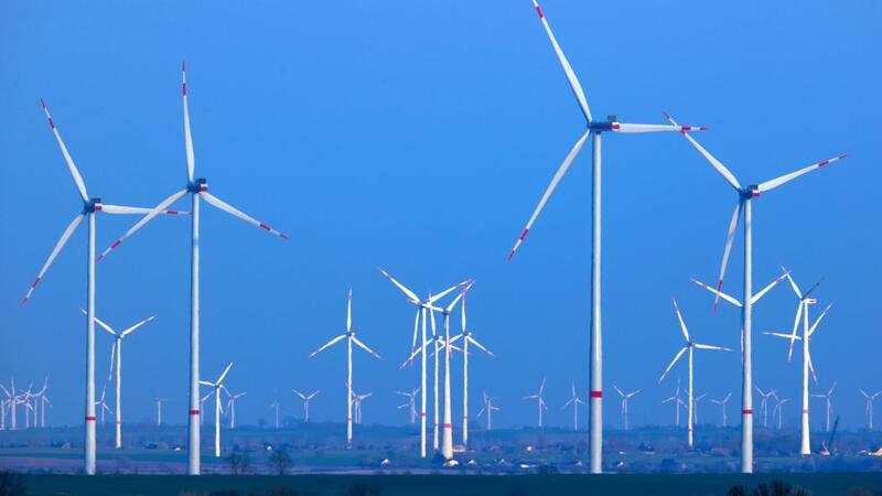 Windräder drehen sich nach Sonnenuntergang in einem Windpark.