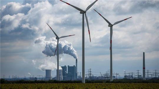 Windräder drehen sich vor der Kulisse des Braunkohlekraftwerks Schkopau westlich von Halle (Saale).