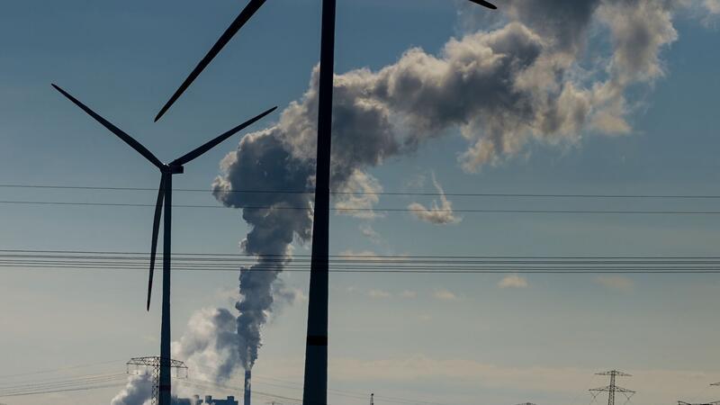 Windräder im Energiepark Bad Lauchstädt, eine Stromtrasse und qualmende Schornsteine in einem Industriegebiet.