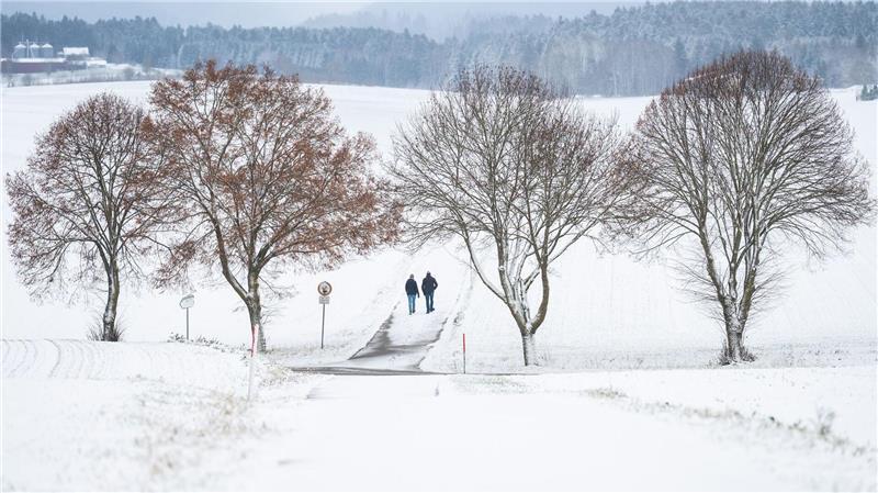 Winterwetter bei Bösingen: Fußgänger auf verschneitem Weg im Schwarzwald.