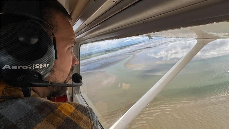 Flug zwischen Watt und Wolken – so werden Seehunde gezählt Wissenschaftler Ole Stejskal hält Ausschau nach Seehunden auf Sandbänken.