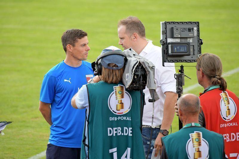 Wolff Fuss, Kommentator des Bezahlsenders „Sky“, interviewt vor dem DFB-Pokal-Spiel gegen den FC Bayern den damaligen D/A-Trainer Lars Uder. Archivfoto: Elsen