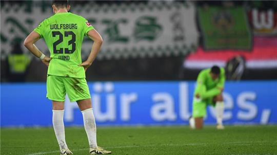 Wolfsburgs Jonas Wind (l) und Wolfsburgs Maxence Lacroix stehen nach dem Schlusspfiff auf dem Feld.