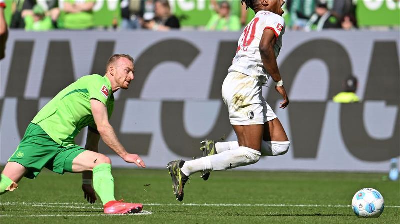 Wolfsburgs Maximilian Arnold foult Freiburgs Junior Adamu und sieht dafür die Rote Karte.